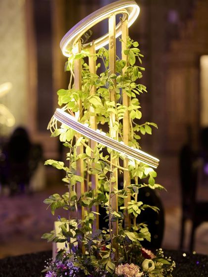 A close-up of the modern table centerpieces, which feature a sculptural design with integrated ring lights and fresh greenery.