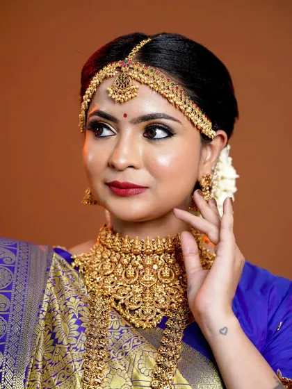 A close-up of the bride, showing the intricate details of the choker and the matha patti.