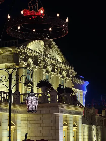 A view of the Buckingham Palace replica from the recreated streets of London. The warm lighting on the palace facade creates a sense of depth and realism, making guests feel like they are truly there.