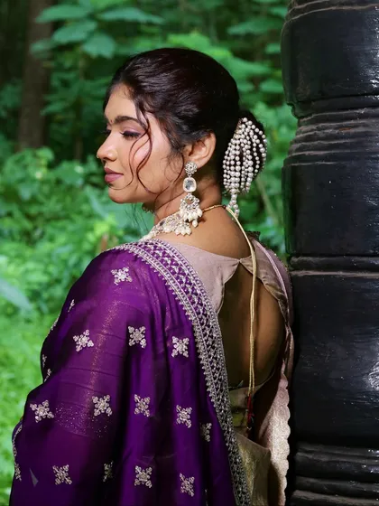 Another angle of the pearl-adorned bun, showing how it complements the bride's profile and the details of her outfit.