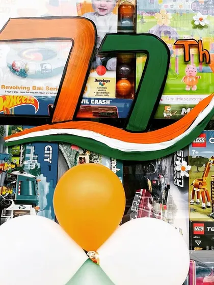 A painted '77th' sign to celebrate Independence Day, combined with tricolor balloons. I can create custom props and signs to match the theme of your event.