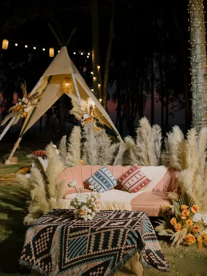 The "Seaside Serenity" Mehendi featured a boho-glam setup with teepees, pampas grass, and a blush velvet couch. This cozy nook was designed for guests to relax and enjoy the evening under string lights.