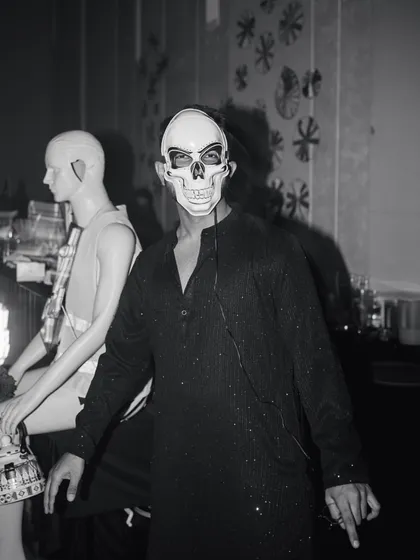 A guest embracing the "dark glam" theme with a skull mask, showcasing the immersive and theatrical nature of the afterparty.