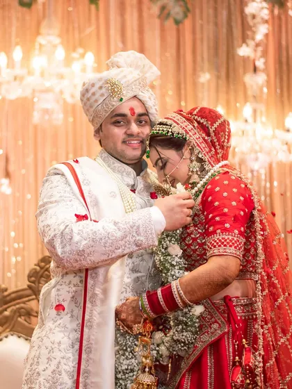 A tender moment right after the Varmala, where the groom helps the bride. These small, candid interactions are just as important as the main rituals.