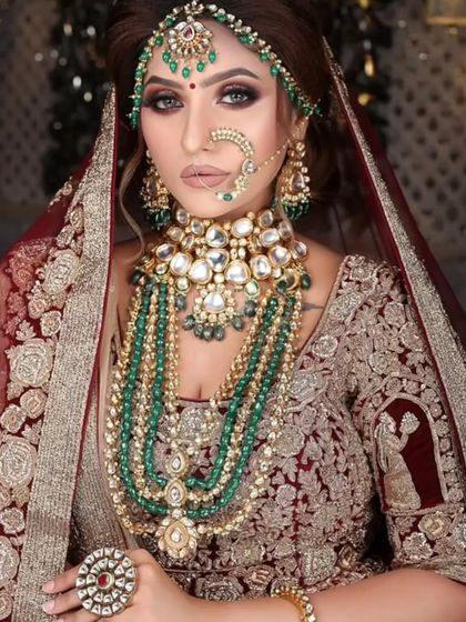 A magnificent, multi-layered Kundan and emerald bead jewellery set, perfect for a royal bridal look.