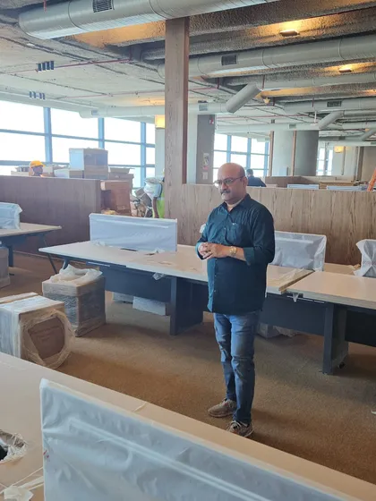 Standing in a large office, I explain to the management how the layout can be optimized according to Vastu to foster better teamwork and reduce workplace stress.