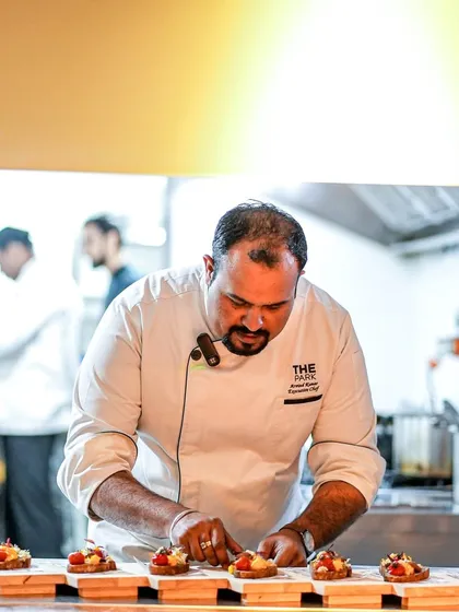 Our Executive Chef meticulously plates a dish for the 'Forgotten Greens' dinner. Every detail is crafted with passion and precision.