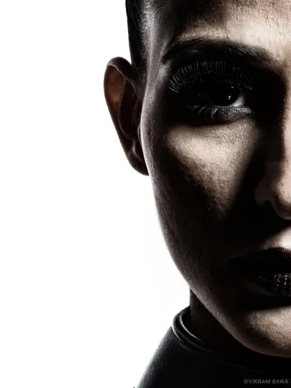 Shadow whispers. A high-contrast, abstract beauty shot focusing on half of the face, creating a sense of mystery and drama.