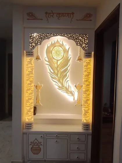 This elegant mandir was made with a Corian finish and features a 'Hare Krishna' mantra and peacock feather design with beautiful backlighting.