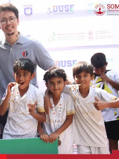 A coach celebrates with our U-9 players, highlighting the strong bond and mentorship within our academy.