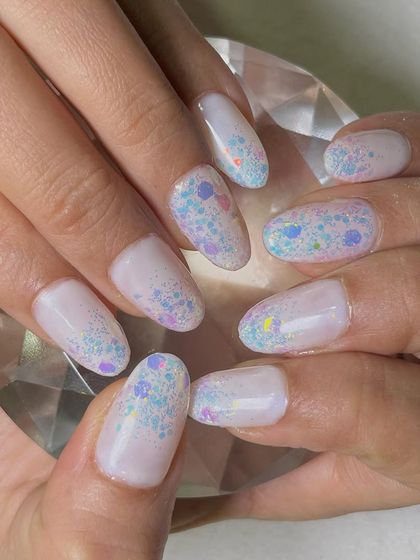 A playful and sparkling inbuilt glitter design. This technique involves encapsulating multi-colored, chunky glitter within the nail extension for a smooth finish with incredible depth and shine.