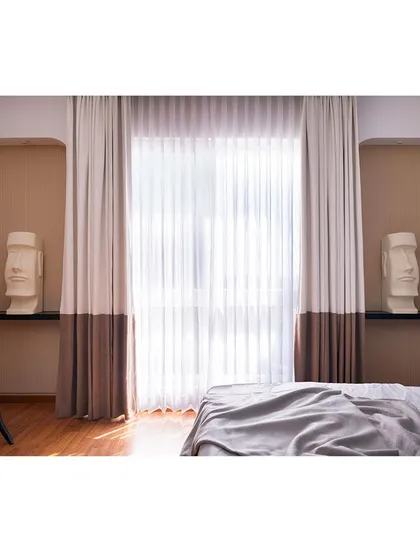 The niches flanking the window serve as perfect display areas for the client's sculptures. The two-toned curtains add another layer of custom detail to this art-filled bedroom.