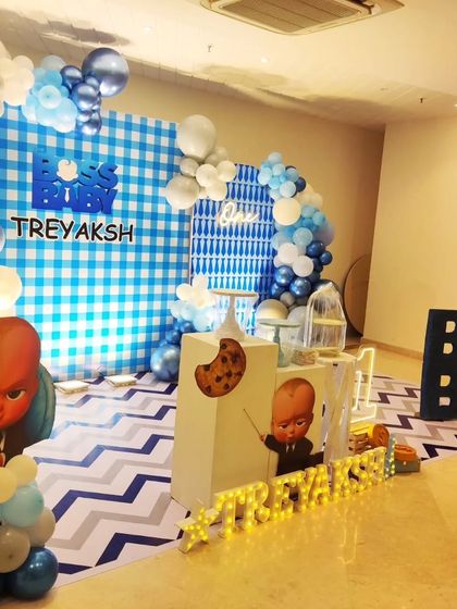 A Boss Baby setup featuring a blue gingham backdrop and a fun zig-zag floor pattern, with character cutouts ready for business.