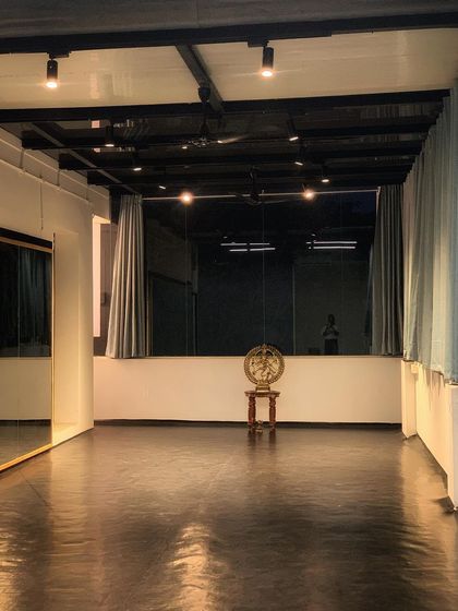 A view of the studio at night. The track lighting and large mirrors create a professional environment perfect for focusing on technique and performance.