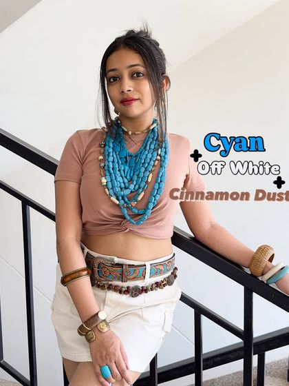 For a more earthy summer palette, try cyan, off-white, and cinnamon dust. I've layered chunky cyan necklaces over a neutral top and shorts to create a bohemian look that's perfect for a hot day.