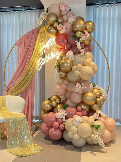 This elegant ring backdrop is one of my popular choices for chic birthdays and events. Here, I've styled it with a cascading balloon garland in shades of dusty rose and chrome gold, accented with fresh flowers and a sequin drape for a touch of glamour.