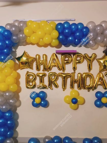 A blue, yellow, and silver balloon arrangement for a birthday celebration at home.