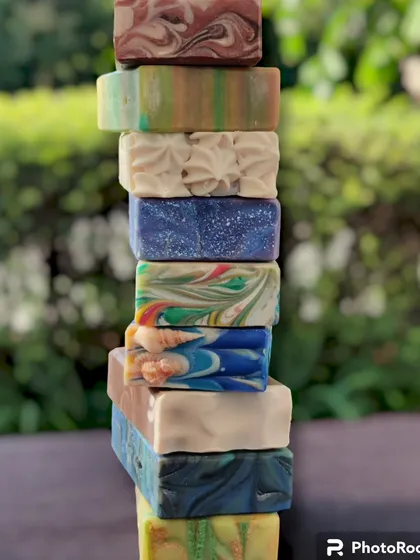 A stack of my handmade cold process soaps, showing the wide variety of colors, textures, and designs I offer. Each one is a unique creation.