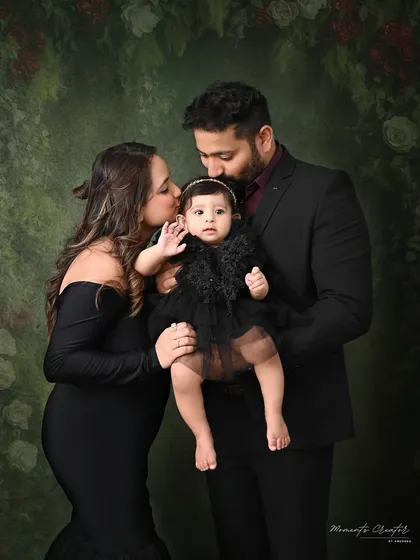 A portrait of pure elegance. This family chose a classic, formal style with coordinated black outfits against a rich, painterly backdrop, creating a timeless and sophisticated family photograph to cherish forever.