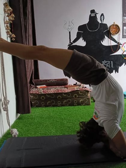 Using the wall and ropes to practice a backbend from a headstand position. This is an advanced technique for opening the spine.
