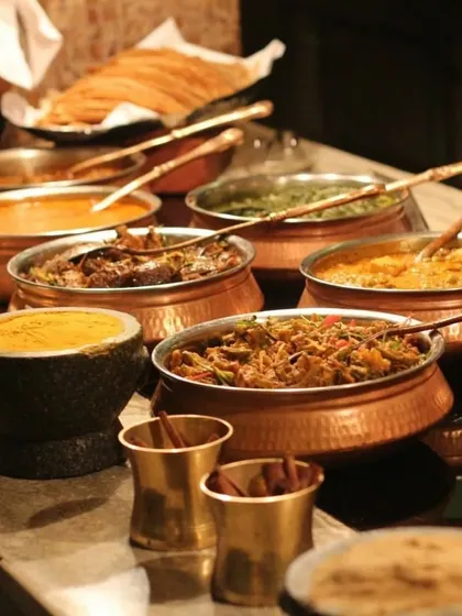 I believe presentation is just as important as taste. Here is a glimpse of a traditional Indian feast served in authentic copper and stone bowls, adding a touch of elegance and heritage to your event's dining experience.