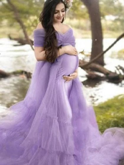 A client enjoying a peaceful moment by the water in a lavender tulle gown. The soft, pastel color and flowing fabric create a serene and romantic atmosphere.
