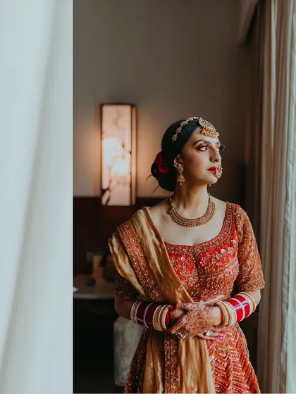 A classic bridal portrait, with the bride looking out a window, capturing a moment of quiet contemplation.