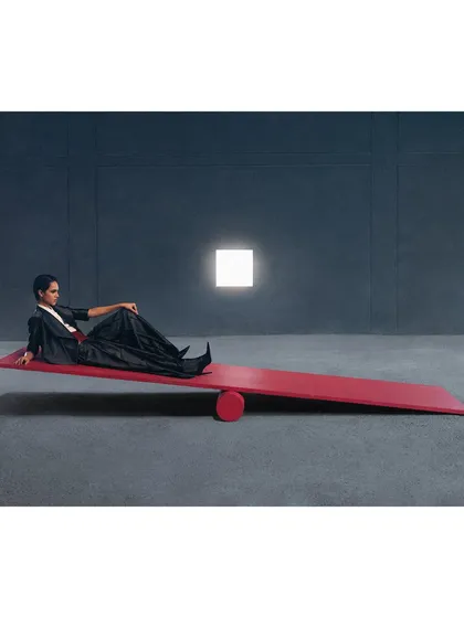 A conceptual shot featuring a red seesaw. This image for Payal Khandwala plays with the ideas of balance, color, and minimalism in a stark, architectural space.