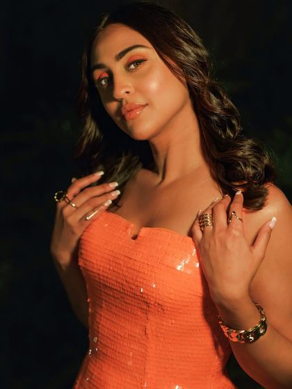 A close-up on the orange-toned makeup for Krystle D'souza. The warm, monochromatic look on the eyes is a modern trend that we love creating.