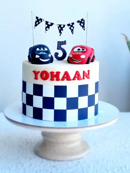A Lightning McQueen-themed cake with a checkered fondant pattern. I teach how to create clean, sharp lines for patterns like this and how to model cute, cartoonish cars.