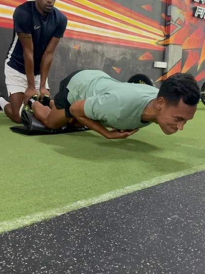 The Nordic Curl is a cornerstone of our hamstring program. Here, an athlete performs the exercise with partner assistance, focusing on controlling the eccentric (lowering) phase to build resilience in the hamstrings.