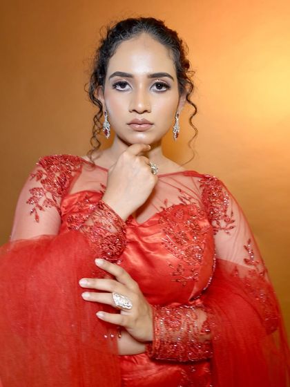 A confident pose showing off the full effect of the glossy makeup. It's a bold look that is perfect for evening events.