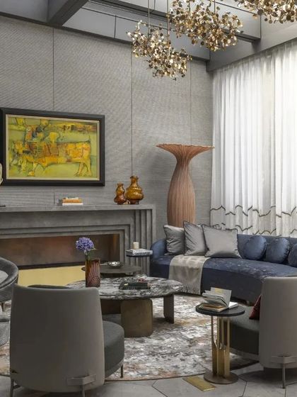 This view captures the full scale of the living room, with its high ceilings and expansive windows that flood the space with natural light. The layout is designed for conversation and connection.