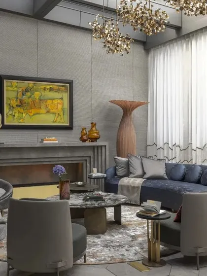 This view captures the full scale of the living room, with its high ceilings and expansive windows that flood the space with natural light. The layout is designed for conversation and connection.