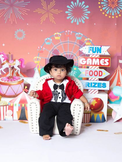 The little ringmaster takes a seat on a mini throne in this vibrant carnival-themed photoshoot.