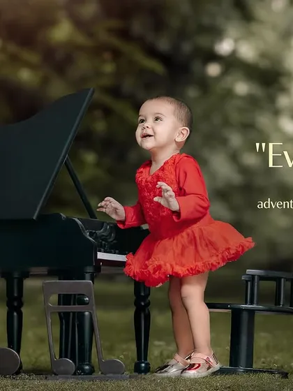 Every day is a new adventure with you. A little girl in a red dress stands and plays the piano in the park.