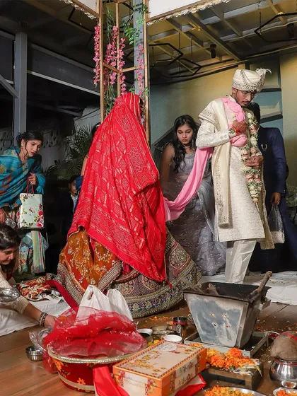 The couple taking their first steps together during the pheras. This candid shot captures the movement and tradition of the ceremony, with family looking on, documenting a pivotal step in their journey.