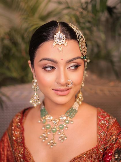 A side profile showing the elegant updo and the soft, defined makeup. This is a timeless look for any formal occasion.
