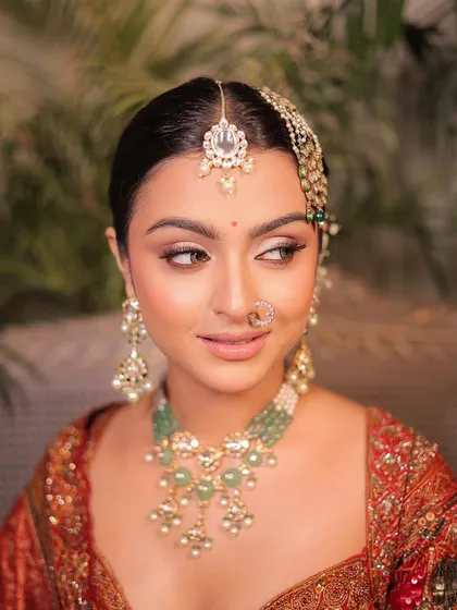 A side profile showing the elegant updo and the soft, defined makeup. This is a timeless look for any formal occasion.
