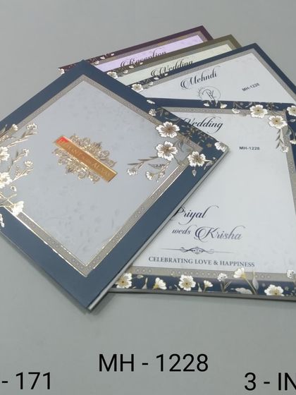A sophisticated invitation set with a navy blue and silver floral theme. The design includes three inserts for a complete and coordinated wedding stationery suite.