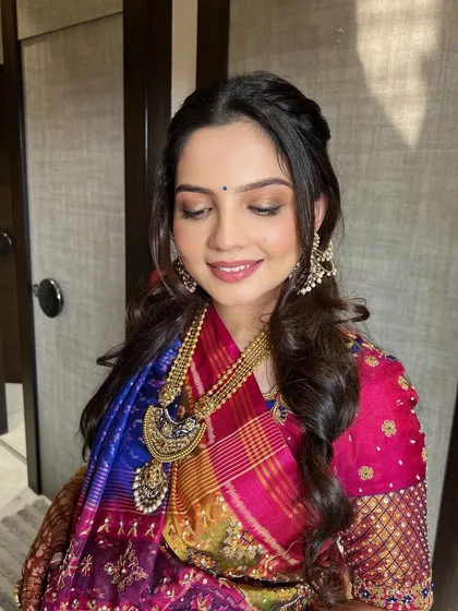 A close-up of the Godh Bharai makeup. The soft peachy-pink hues on the eyes are blended with shimmer, while a hint of blue liner adds a playful, modern touch.