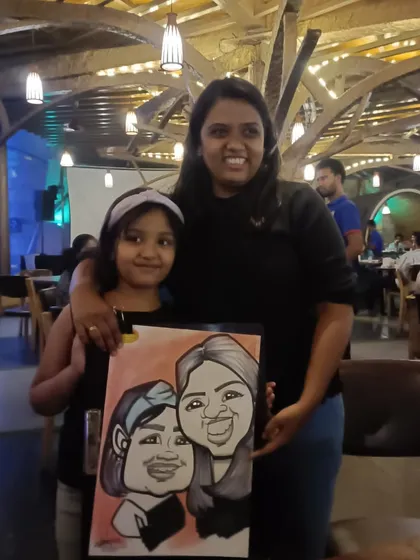 A mother and daughter with their joint caricature, a lovely memory from their dinner.