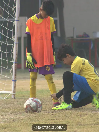 A moment of sportsmanship as one player helps another tie his shoelaces.