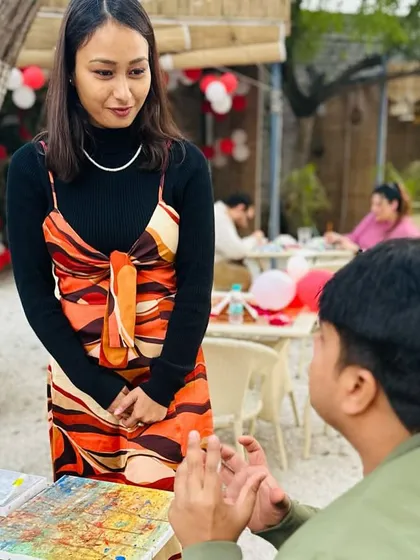 I love these moments of conversation and connection during my workshops. Here, I'm chatting with a participant about his artwork at our outdoor painting event. My goal is to create a comfortable space where everyone feels inspired to explore their creativity.