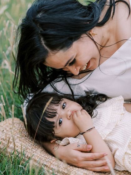 A mother and daughter lying in the grass, sharing a secret. A beautiful, intimate moment.