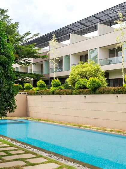 The linear design of the swimming pool is softened by the surrounding landscape. We used stone pavers interspersed with grass joints and strategically placed trees to create a natural, rhythmic transition from the hardscape of the pool deck to the softscape of the lawn.