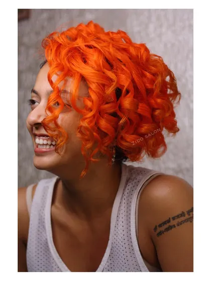 This is pure joy in a hair color. The vibrant, sunny orange completely transforms these curls into a statement piece, proving that curly hair is the perfect canvas for the brightest of colors.