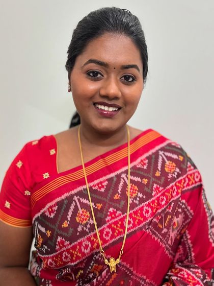 A smiling shot of Subha. Her skin looks healthy and radiant, and the makeup is minimal and elegant.