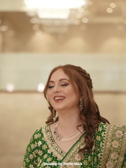A candid laugh captures the essence of this bride's joy. Her engagement look in a green lehenga is paired with soft, natural makeup that enhances her happiness.