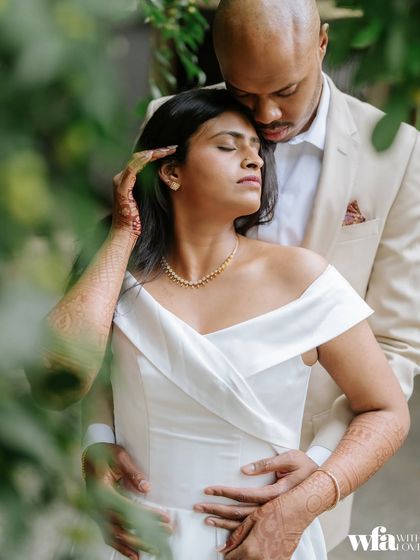 An intimate embrace, framed by greenery, this photo feels private and deeply romantic.